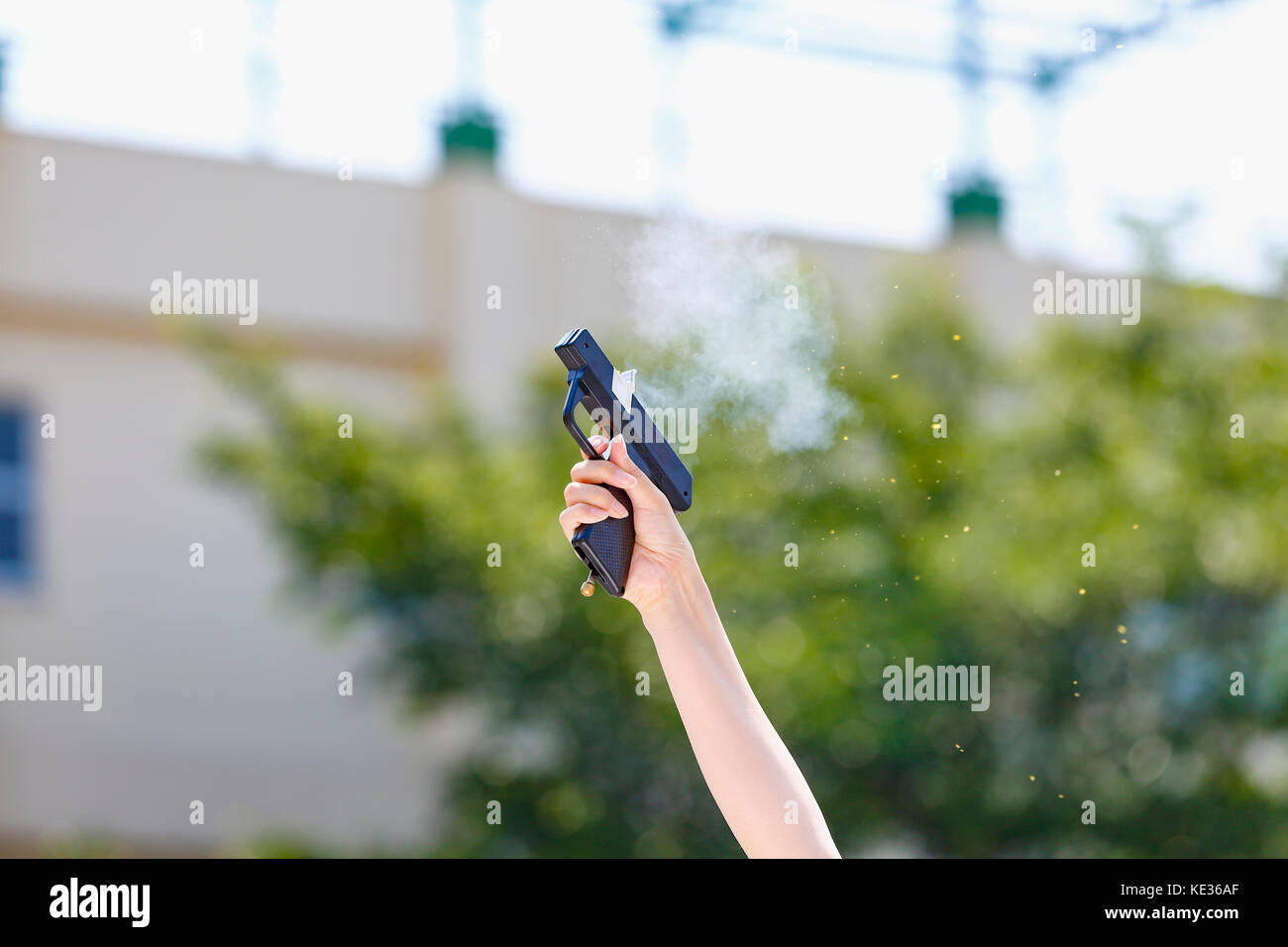 Hand hält Starterpistole im Schulgarten Stockfoto
