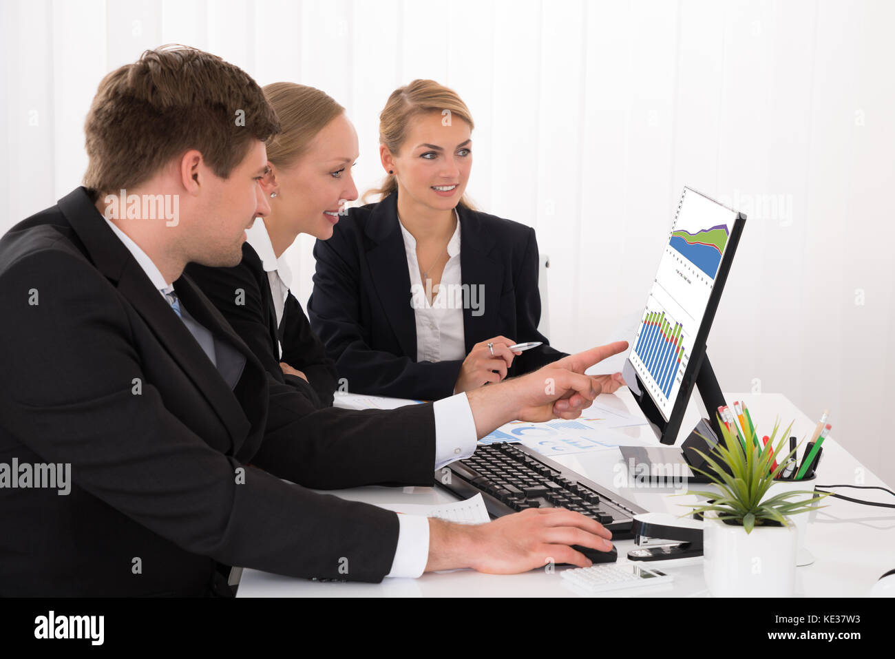 Junge glücklich männlichen und weiblichen Geschäftsleute arbeiten auf die Diagramme in Office Stockfoto
