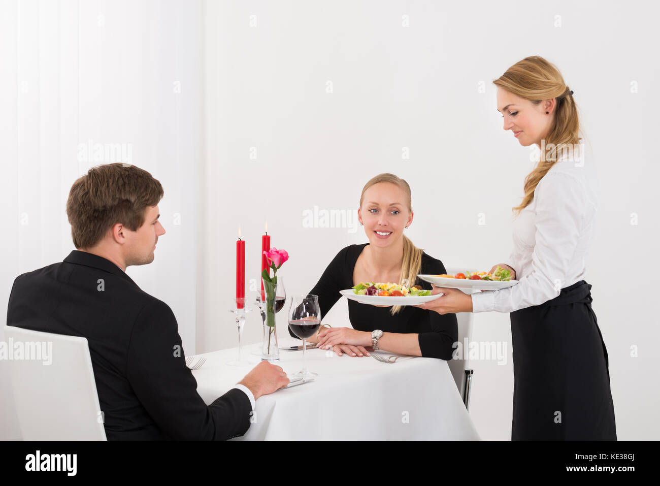 Weibliche Paar Servieren von Speisen zu junges Paar im Restaurant Stockfoto