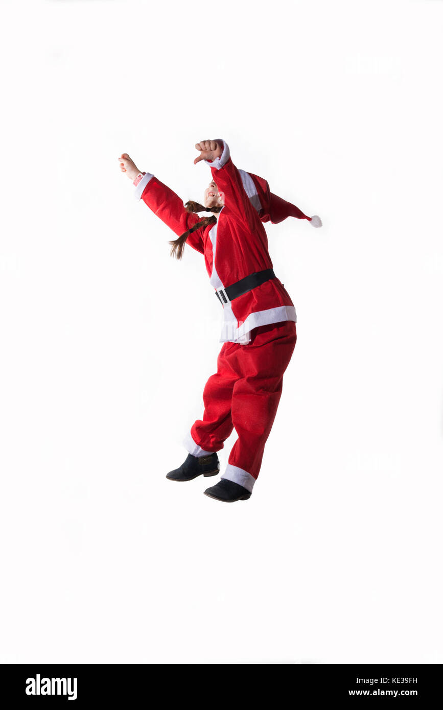 Wenig kaukasische Mädchen verkleidet als Weihnachtsmann Springen auf weißem Hintergrund. Stockfoto
