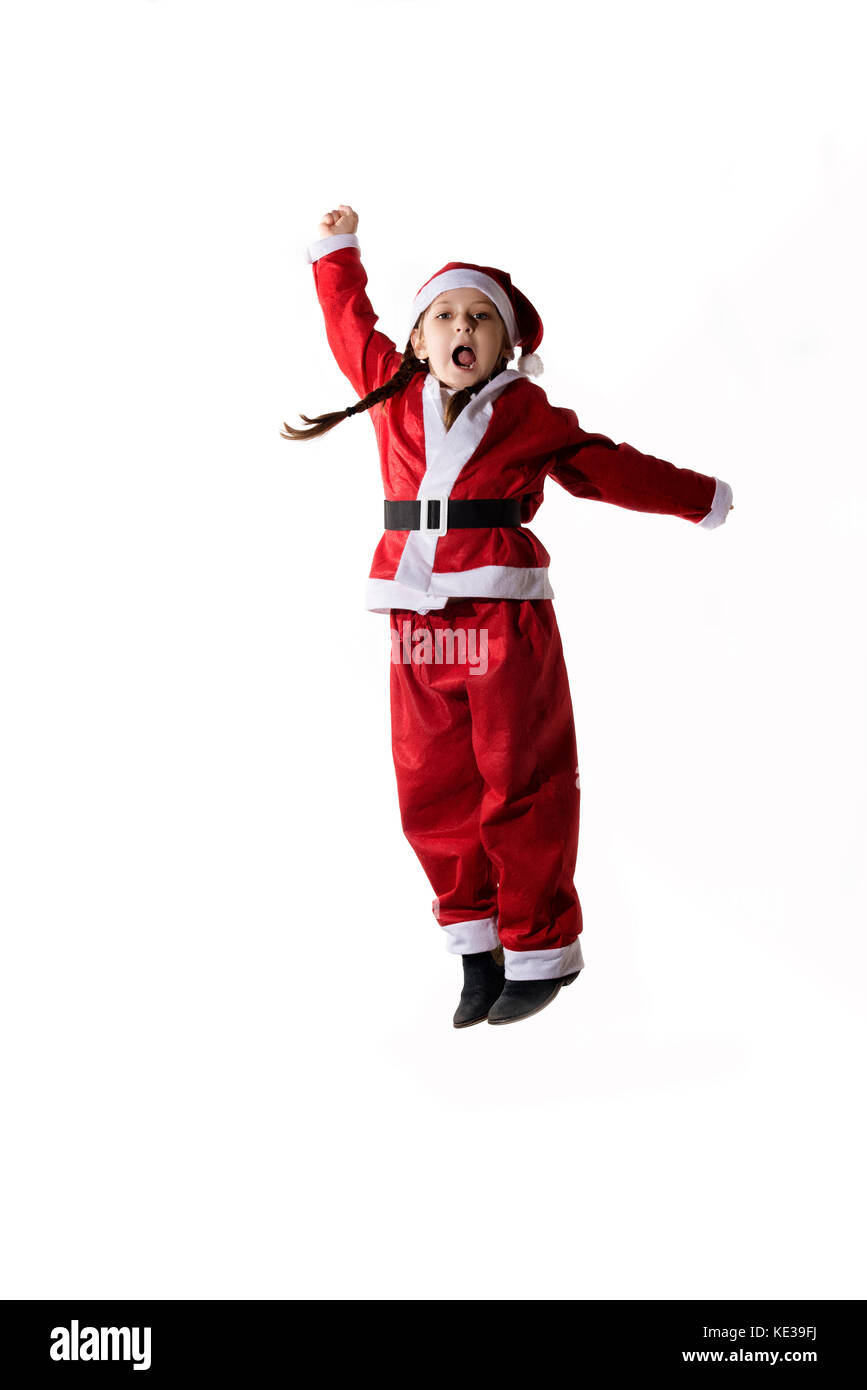 Wenig kaukasische Mädchen verkleidet als Weihnachtsmann Springen auf weißem Hintergrund. Stockfoto