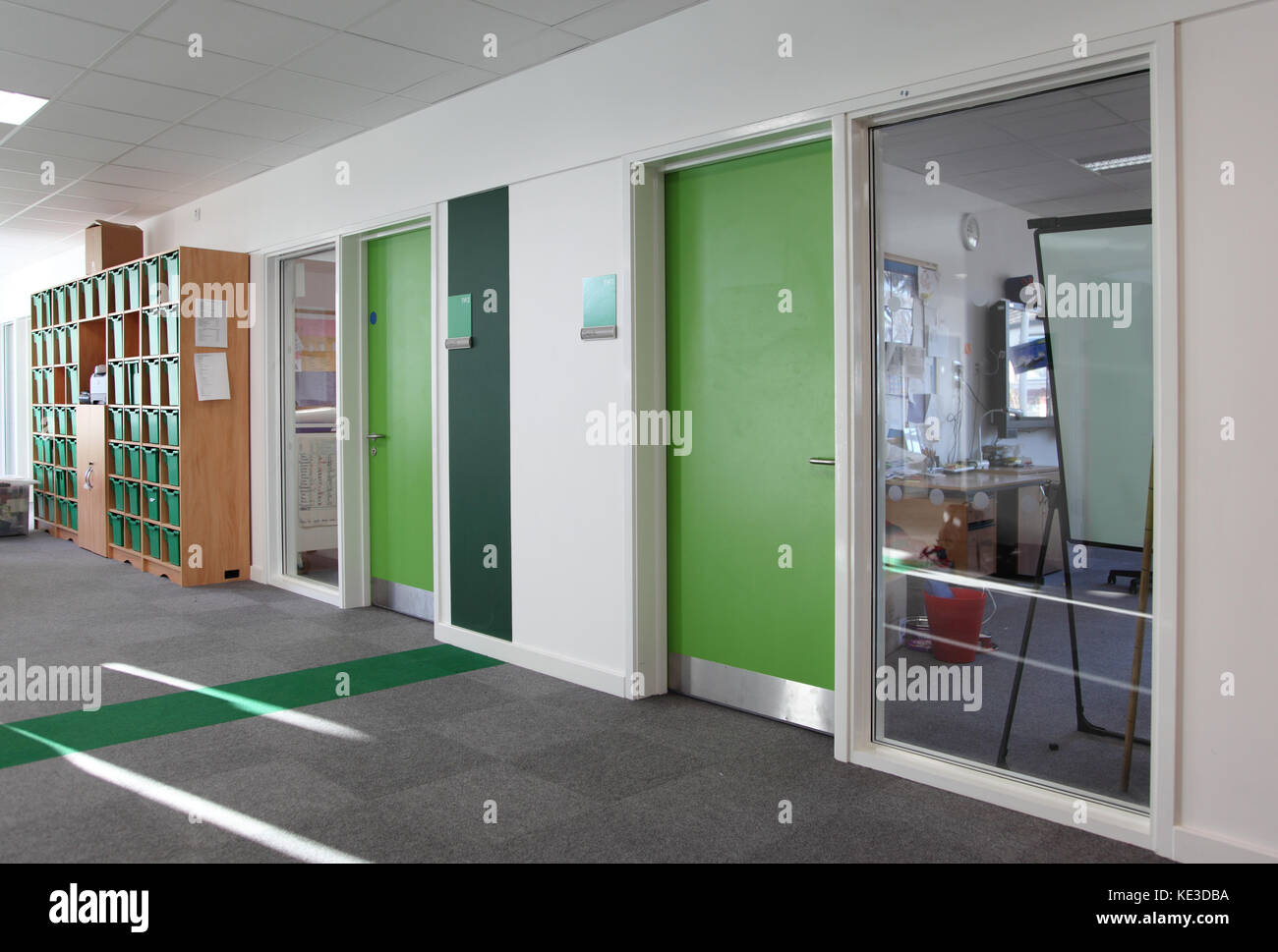 Farbcodierte Klassenzimmer Korridor in einem neuen London Grundschule Akademie. Leer, Türen geschlossen. Stockfoto