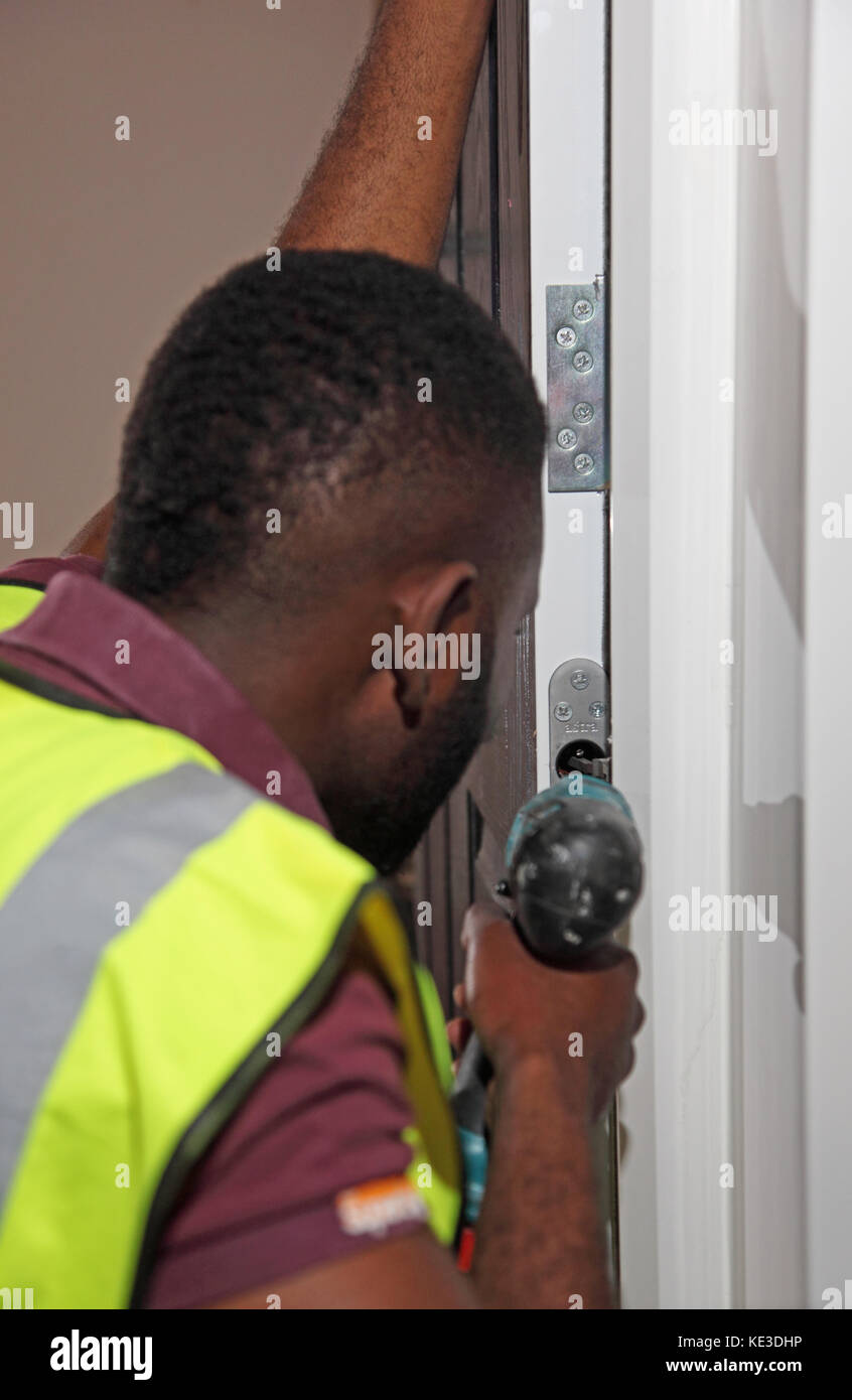 Ein Arbeiter, der während der Renovierung des Scott House, eines im besitz des rates befindlichen Wohnturmblocks in Enfield, Großbritannien, neue Brandschutztüren installierte Stockfoto