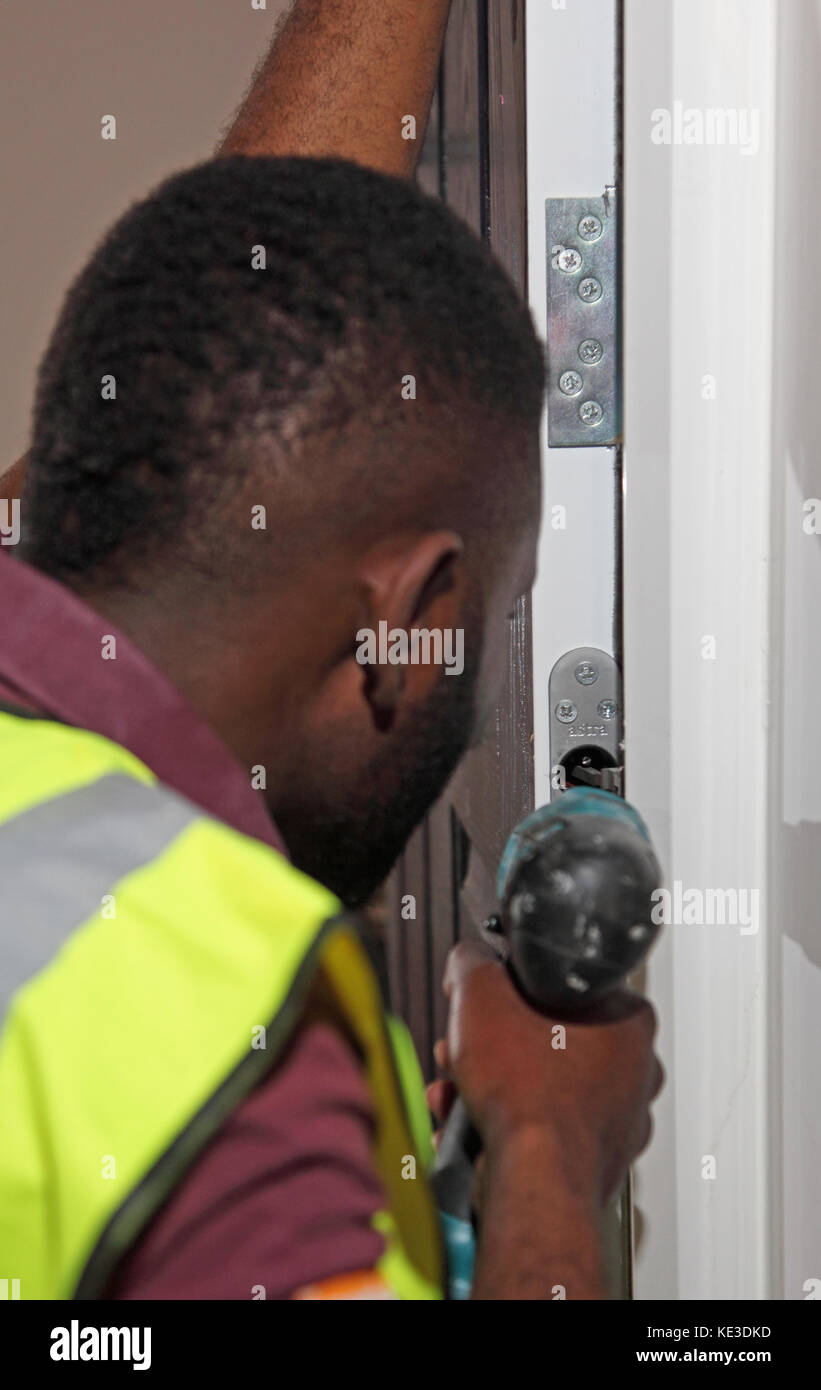 Ein Arbeiter, der während der Renovierung des Scott House, eines im besitz des rates befindlichen Wohnturmblocks in Enfield, Großbritannien, neue Brandschutztüren installierte Stockfoto