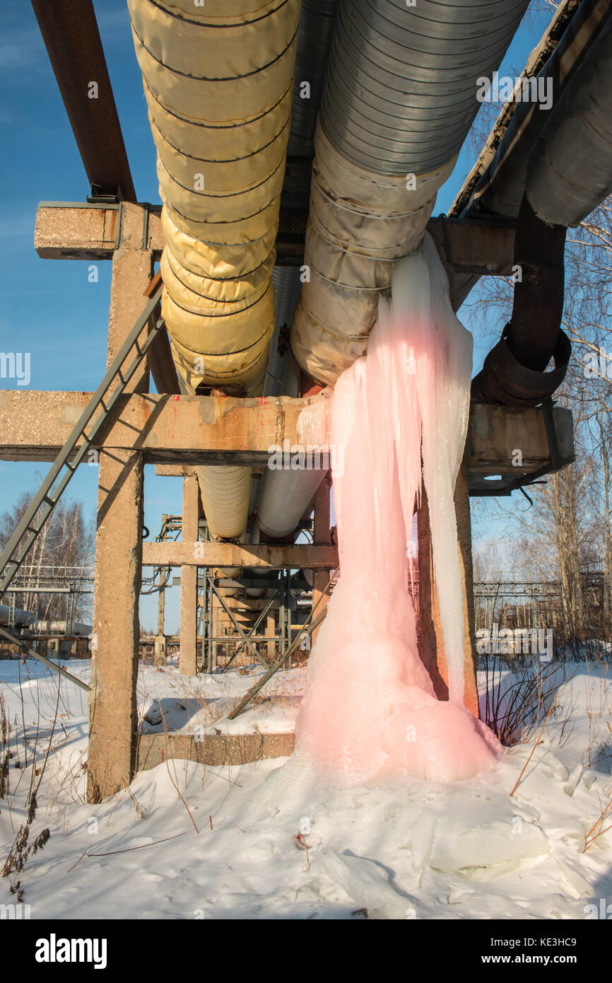 Große rosa Eiszapfen an eine Wasserleitung und den Verlust von Wärme im Winter. Stockfoto