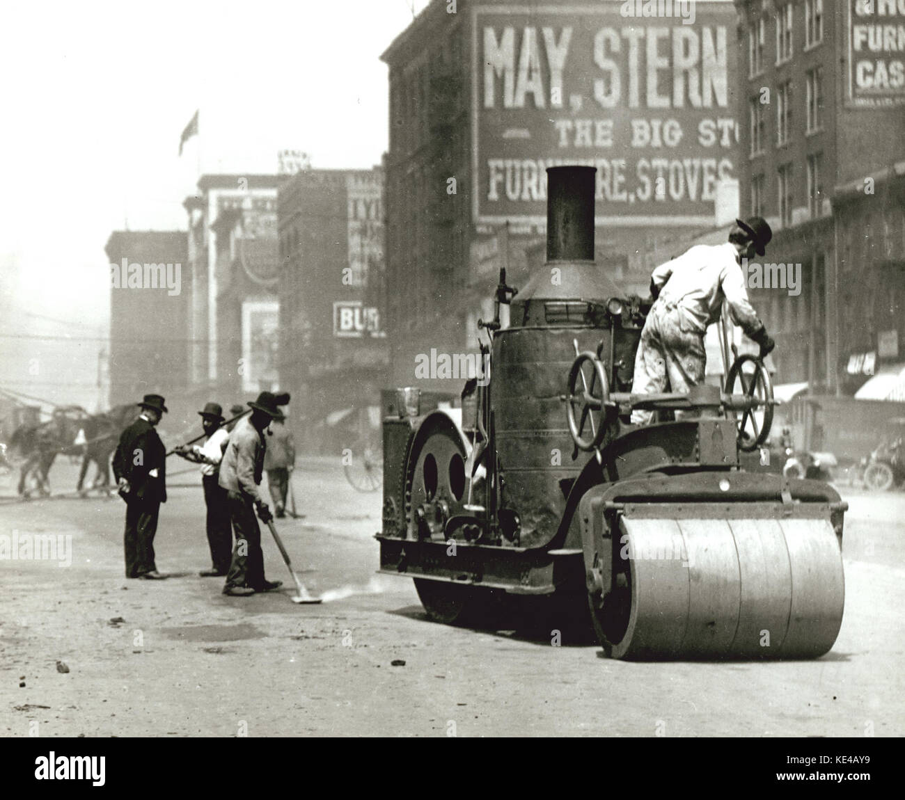 Straße Arbeiter mit einer Dampfwalze zwölften Straße (Tucker Boulevard) zwischen Kastanien und Pinien Straßen zu reparieren. Stockfoto