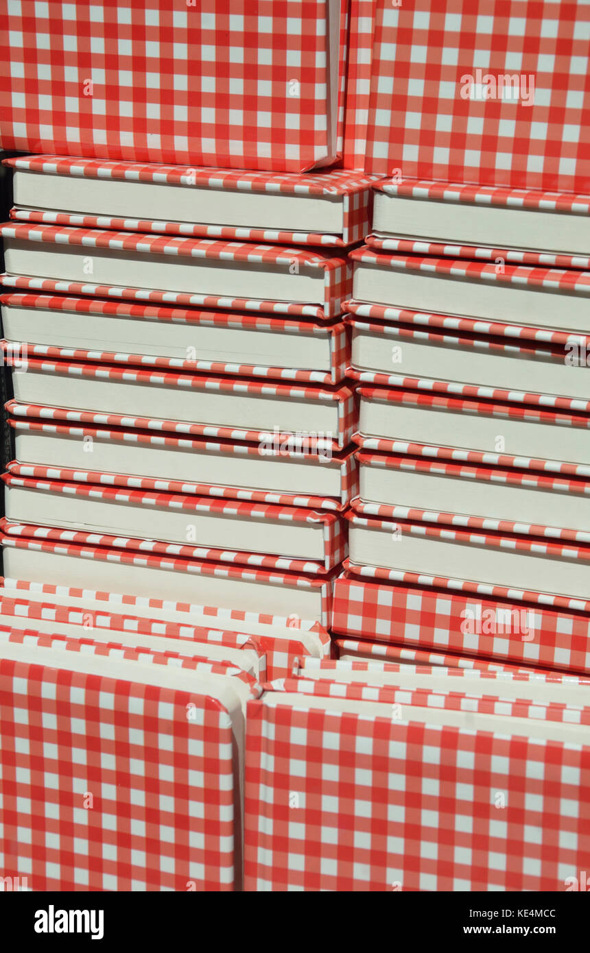 Gestapelte rote und weiße Notebooks. Stockfoto