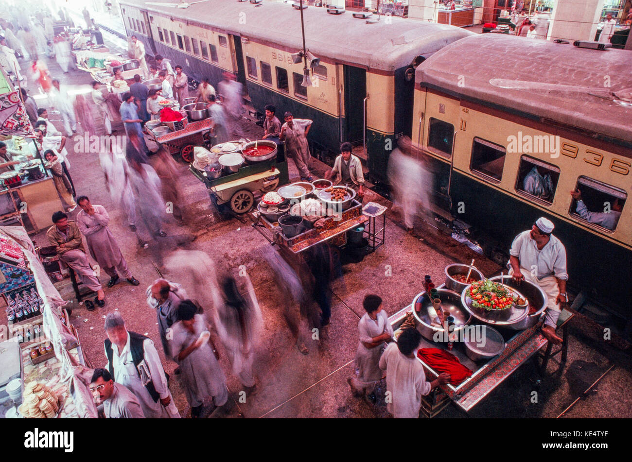 Fast food Verkäufer Leitung der Plattform Bahnhof in Lahore, Pakistan 1990. Stockfoto