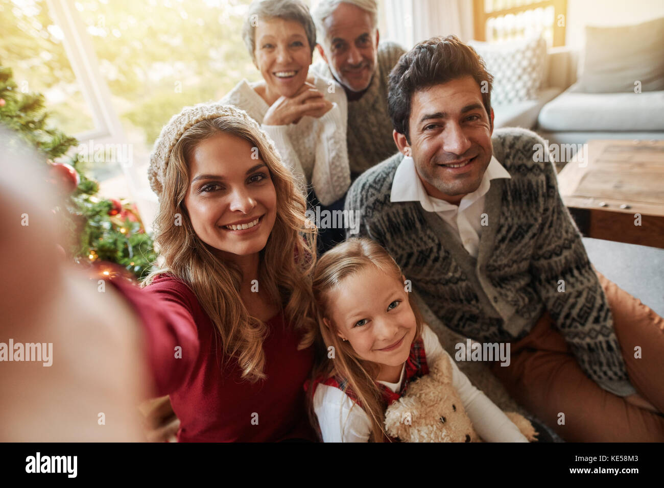 Glückliche Großfamilie unter selfie zu Hause im Wohnzimmer. Frau mit ihrer Familie unter self portrait am Heiligabend. Stockfoto