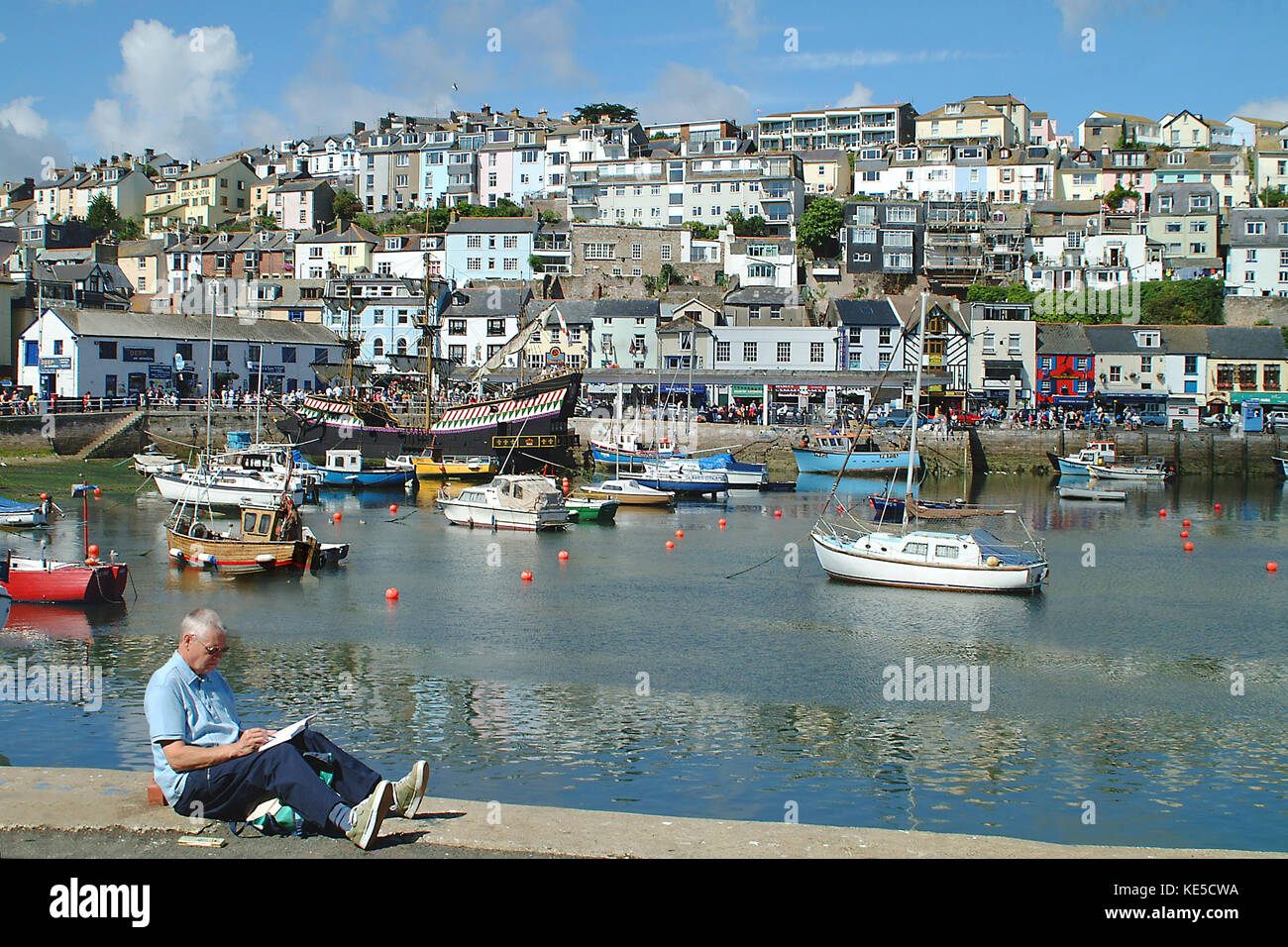 Mann skizzieren Vor dem Hafen von Brixham, Devon, England, Großbritannien Stockfoto