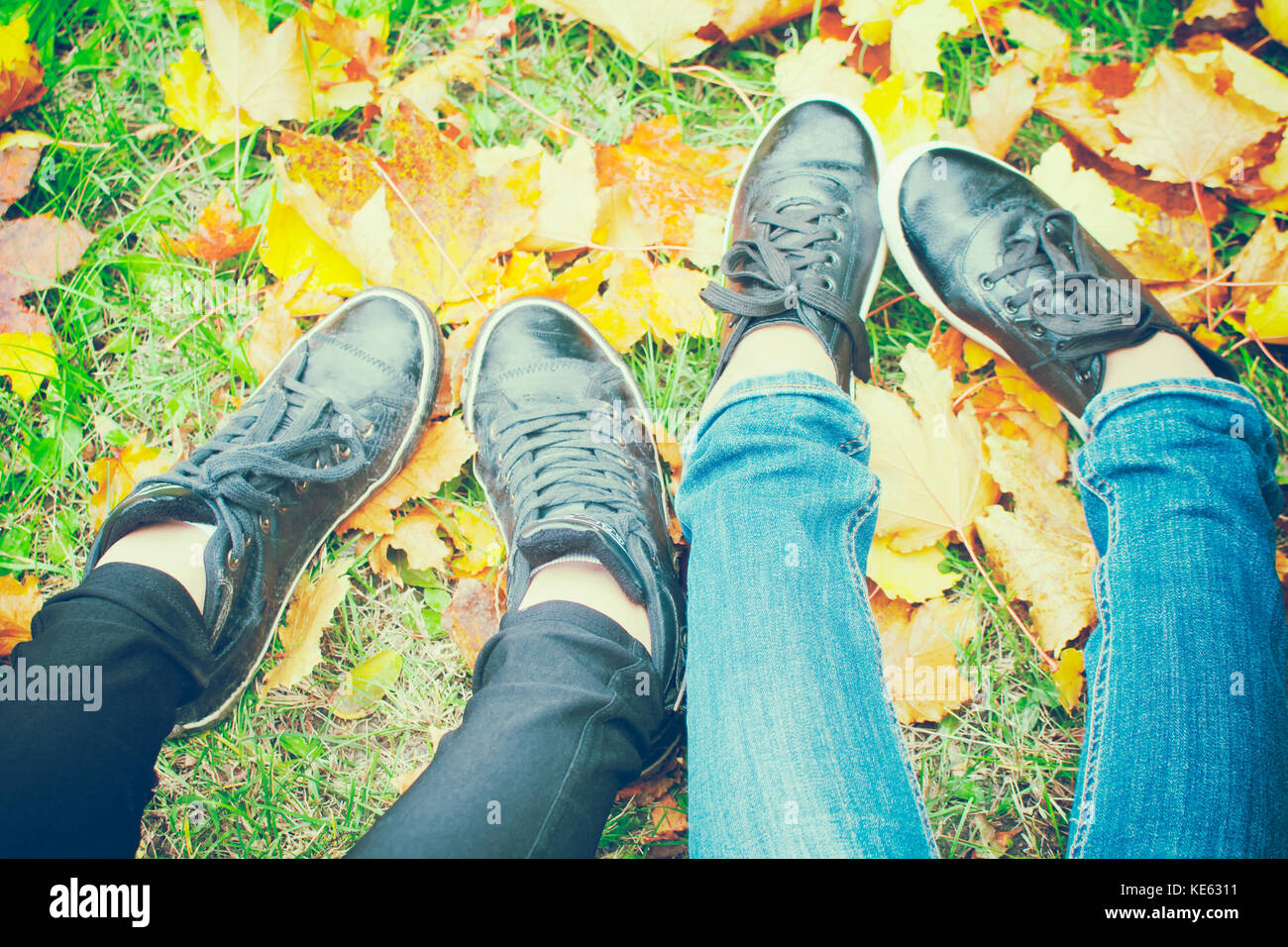 Zwei Mädchen Schuhe auf Blätter im Herbst, Ansicht von oben, getönten Foto Stockfoto