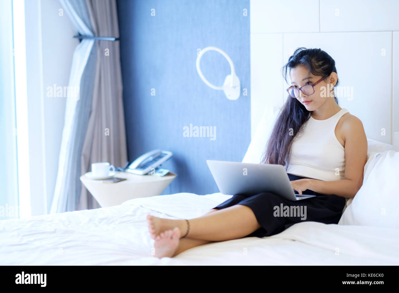 Eine asiatische Frau, die in ihrem Zimmer arbeitet Stockfoto