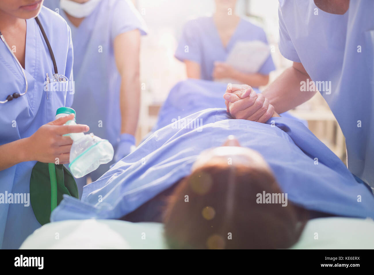 Chirurg hält die Hand des Patienten auf der Bahre Stockfoto