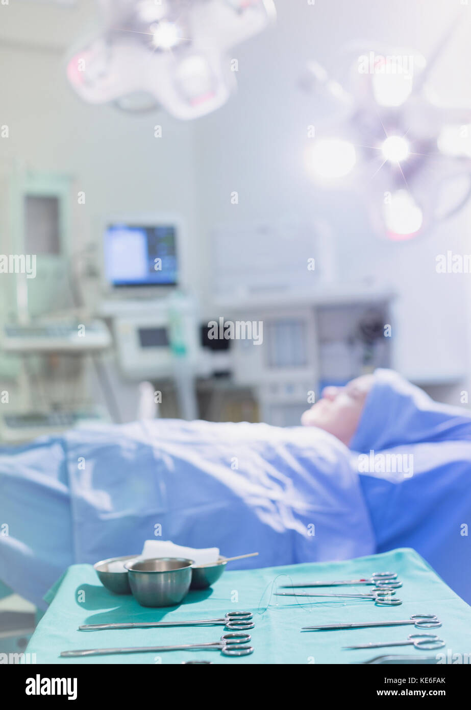 Chirurgische Scheren und Geräte auf Tablett in der Nähe weibliche Patienten in Operationssaal Stockfoto