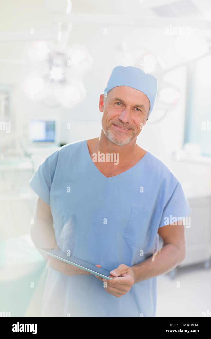 Portrait männlichen Chirurgen mit digitalen Tablette im Operationssaal Stockfoto