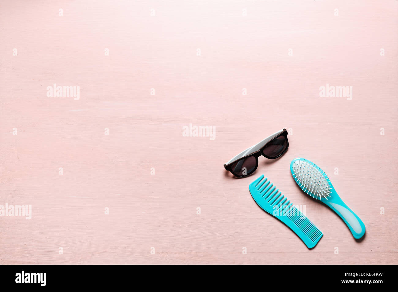 Zwei türkis Haar Kamm Kamm bürsten mit Griff für alle Arten und Sonnenbrille auf rosa Kopie Raum Hintergrund isoliert. Minimalistisch feminine Flach Stockfoto