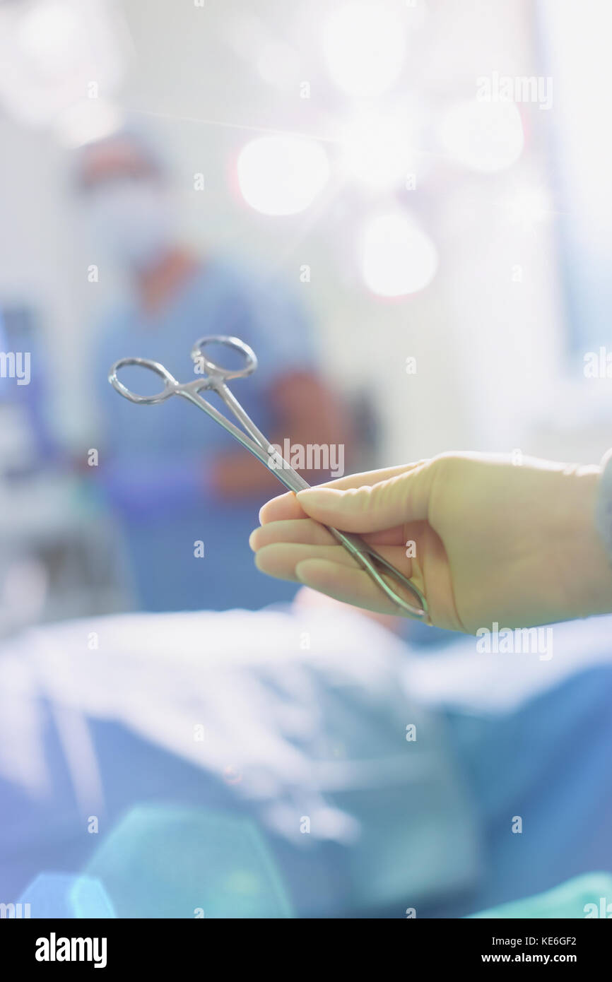 Chirurg trägt Gummihandschuh hält chirurgische Schere im Operationssaal Stockfoto