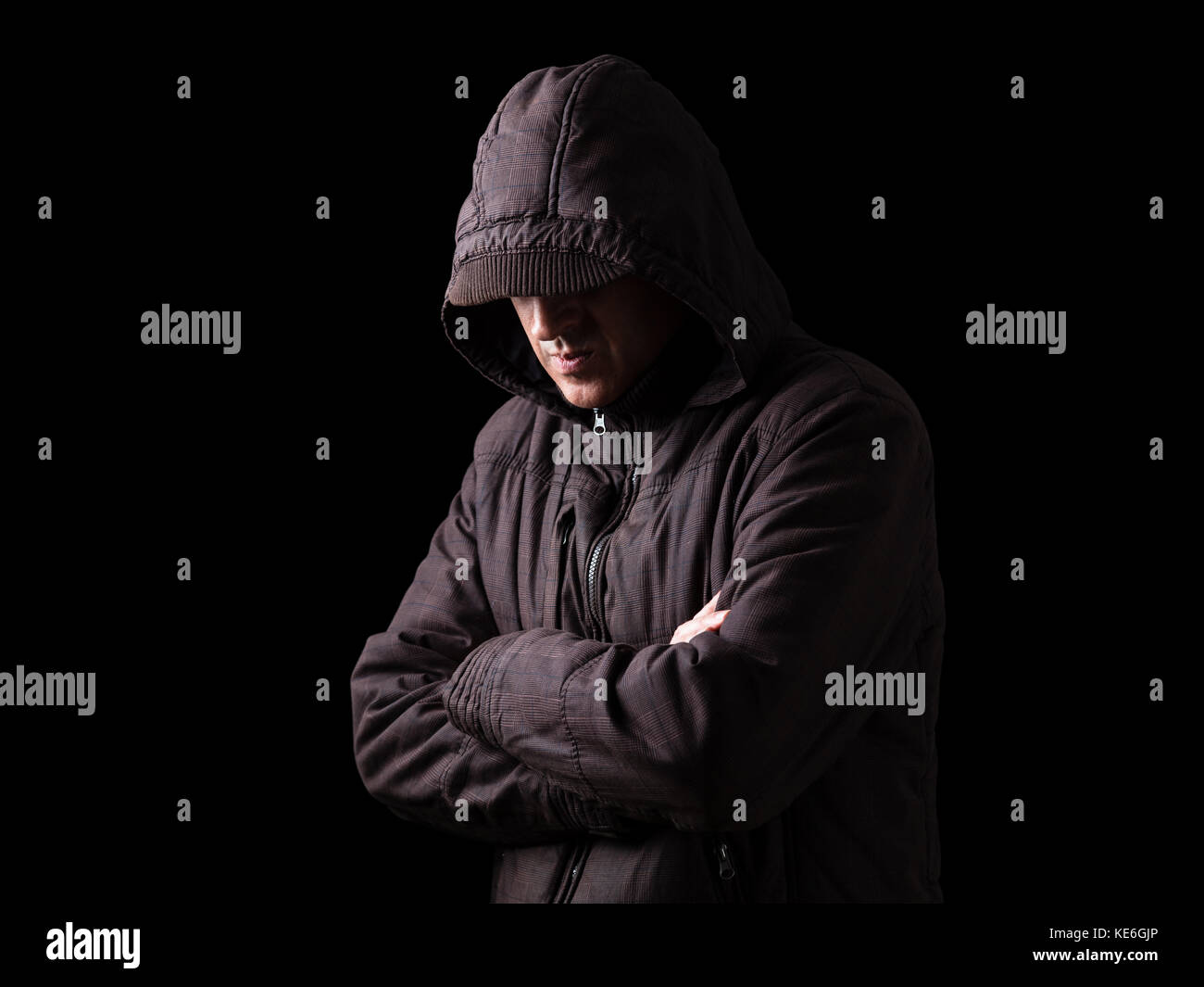 Einsam, depressiv, zerbrechliche Mensch verstecken Gesicht, Arme gekreuzt, stehend in der Dunkelheit. Low Key, schwarz hintergrund/Einsamkeit unglücklich umgekippt Depression Stockfoto