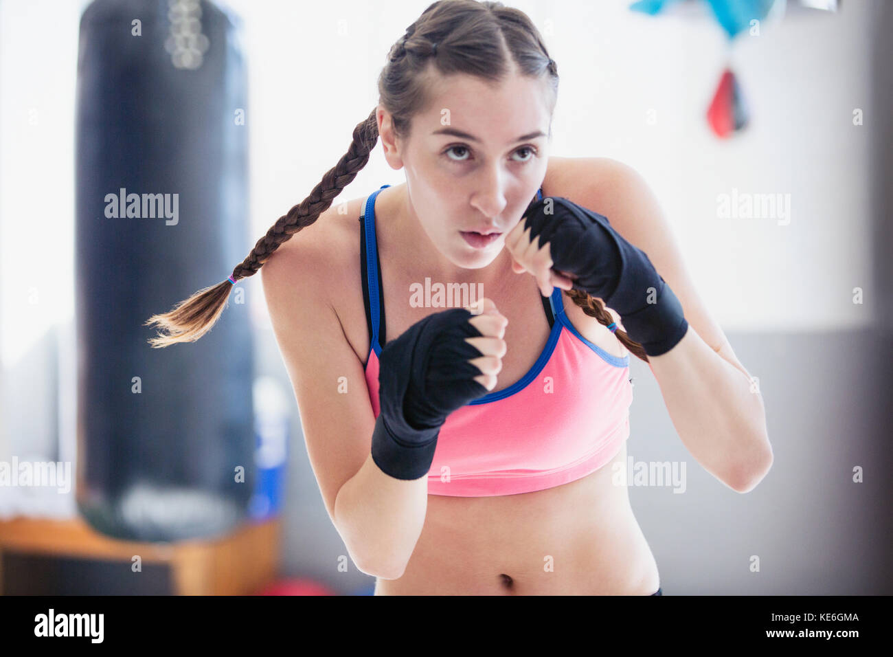 Entschlossenes, hartes junges Boxershadowboxing im Fitnessstudio Stockfoto
