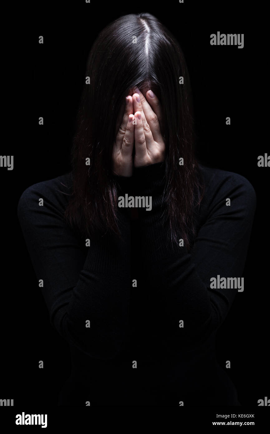 Emotionale Frau weinen und das Gesicht mit den Händen verstecken Tränen. schwarzer Hintergrund/Opfer Depression depressiv Schmerz Trauer Trauer Trauer traurige Traurigkeit Stockfoto