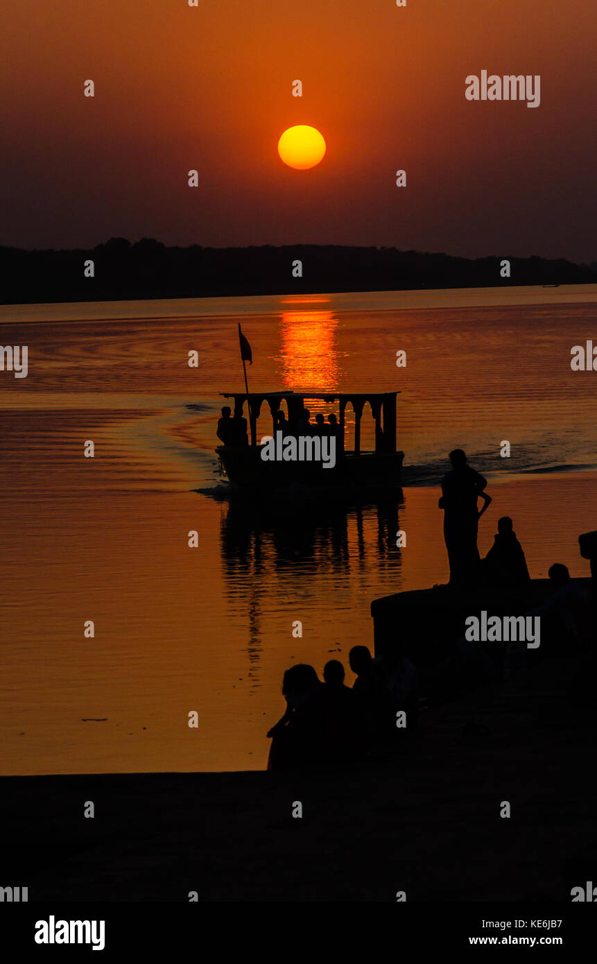 Ein Boot überqueren der Narmada Fluss bei Sonnenuntergang in Maheshwar, Madhya Pradesh, Indien Stockfoto