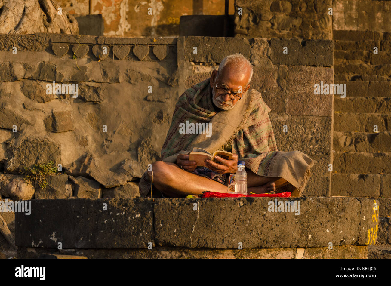 Ein Mann ein Buch auf die ghats von maheshwar, Madhya Pradesh, Indien Stockfoto