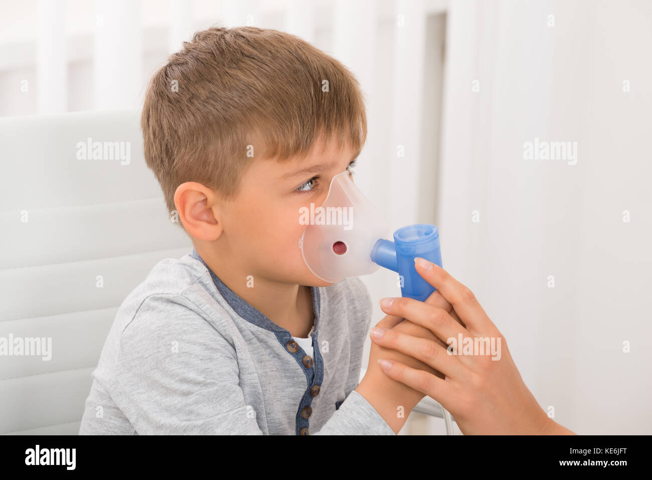 Nahaufnahme eines kleinen Jungen durch Einatmen von Sauerstoff Maske in Klinik Stockfoto