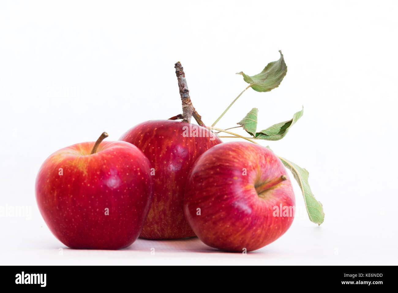 Drei frische natürliche organische rote Heirloom köstliche Nahaufnahme von Bio Apfel mit Stängel und Blätter auf weißem Hintergrund, eine perfekte gesunden Snack Stockfoto