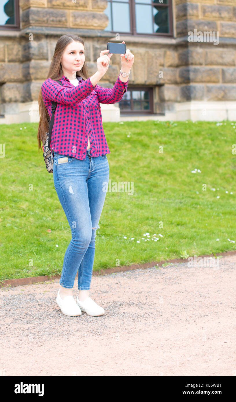 Junge Frau mit langem Haar Smartphone in der Europäischen Altstadt Stockfoto