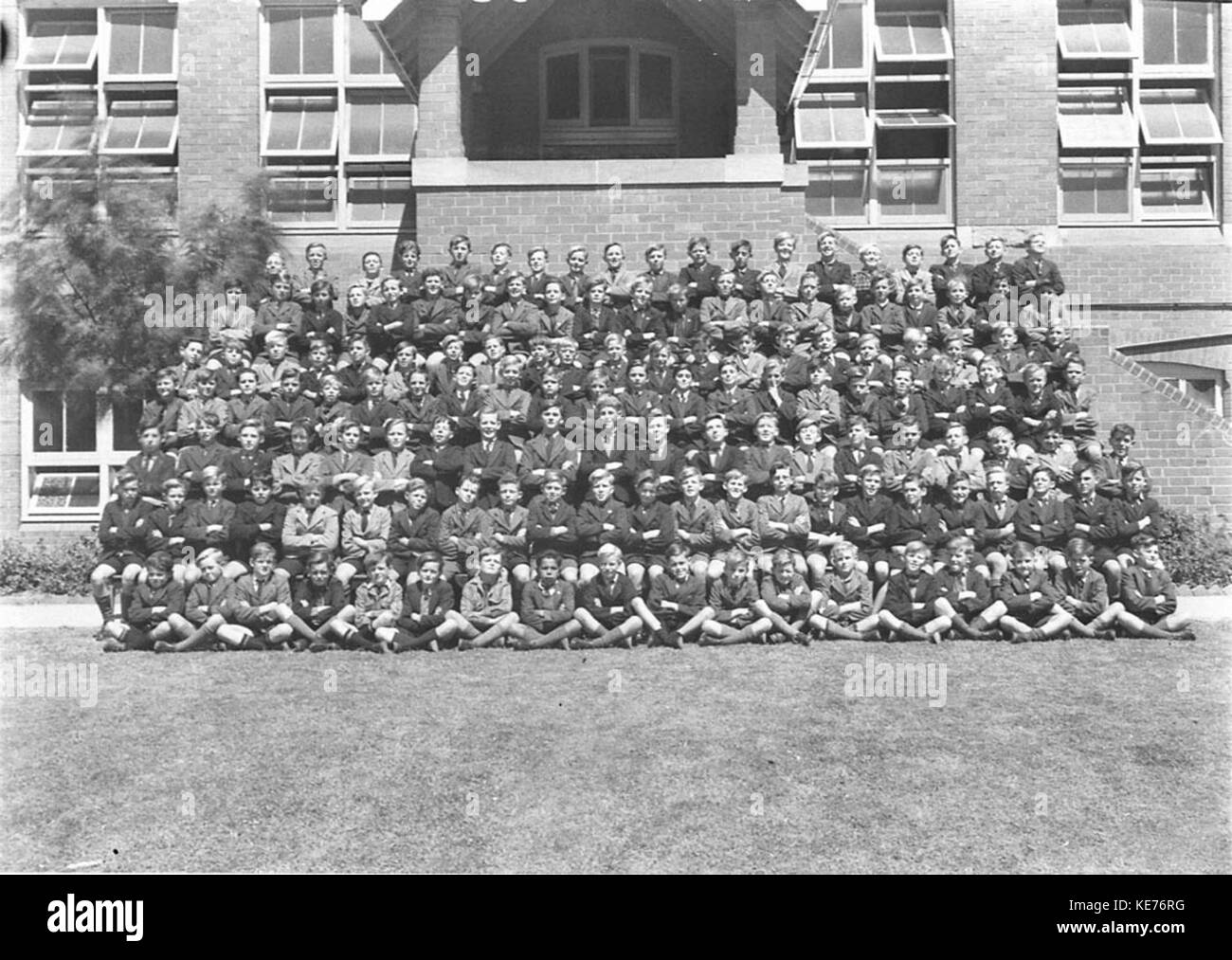 Dieses Bild zeigt eine große Gruppe von Schülern, die für ein Foto posieren. Das Bild fängt einen Moment des Schülerlebens aus einer früheren Zeit ein und bietet einen Einblick in die vergangenen Schultraditionen und -Kleidung. Stockfoto