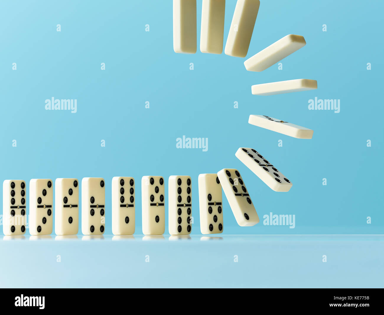 Drehen von Dominos auf blauem Hintergrund Stockfoto