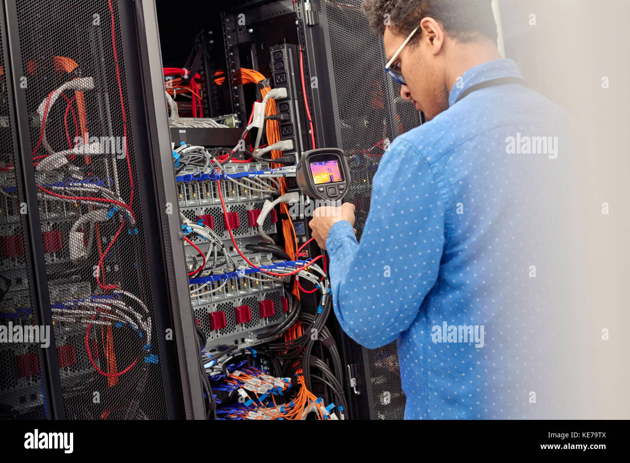 Männlicher IT-Techniker, der die Diagnose an der Zentrale im Serverraum durchführt Stockfoto