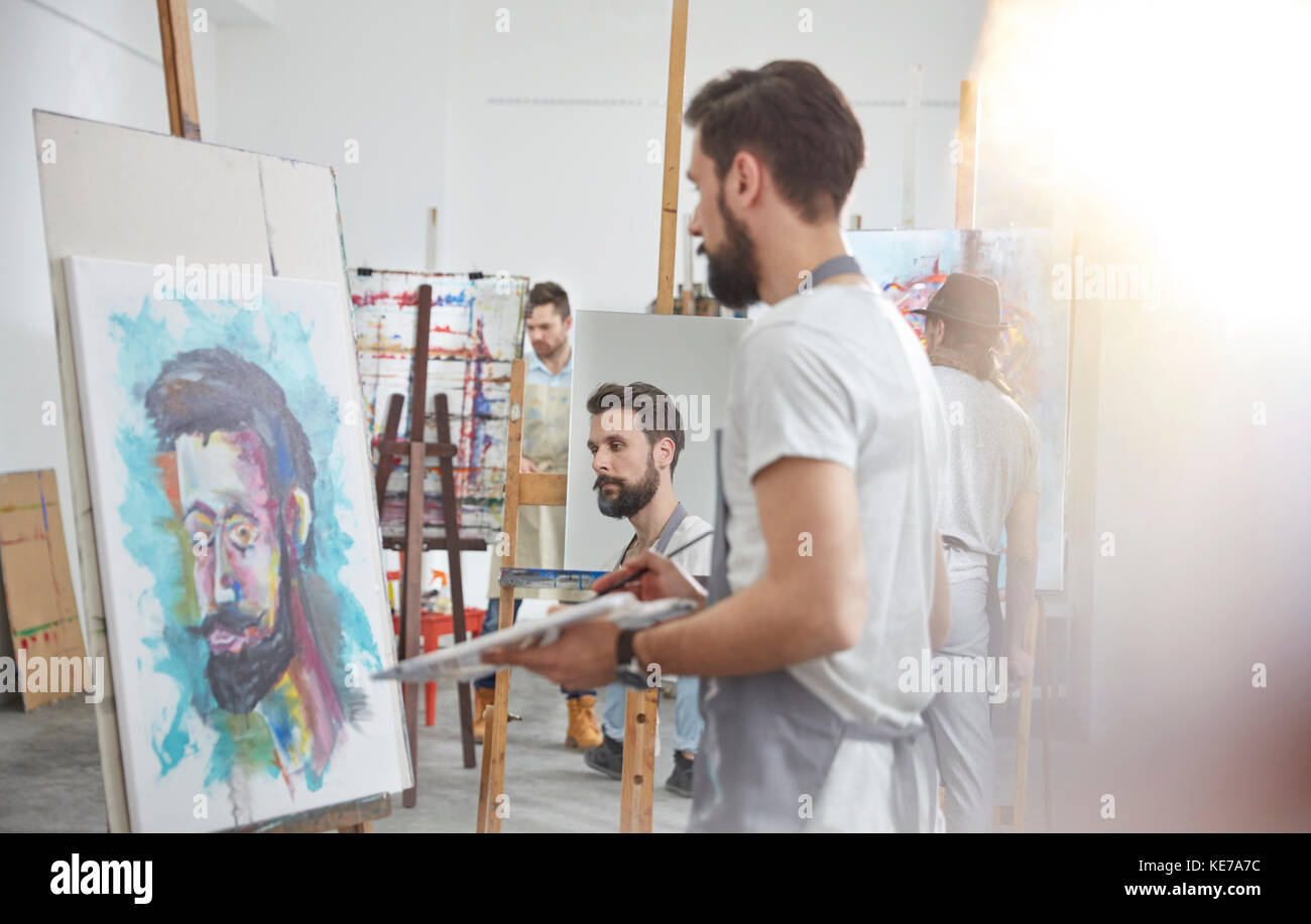 Männliche Künstler malen an Staffelei im Kunstklassestudio Stockfoto