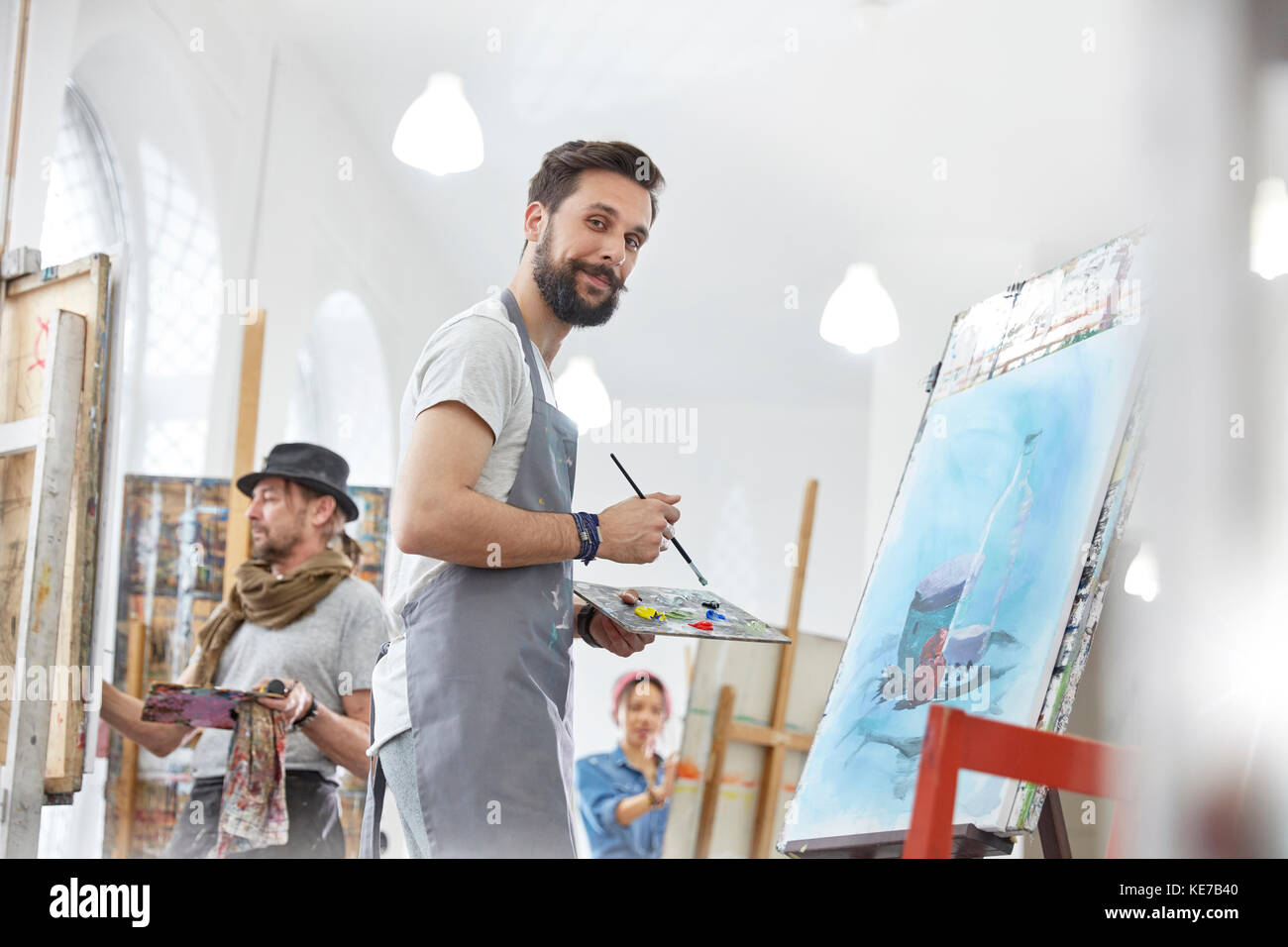 Portrait selbstbewusst männliche Künstler Malerei mit Palette in der Kunstklasse studio Stockfoto