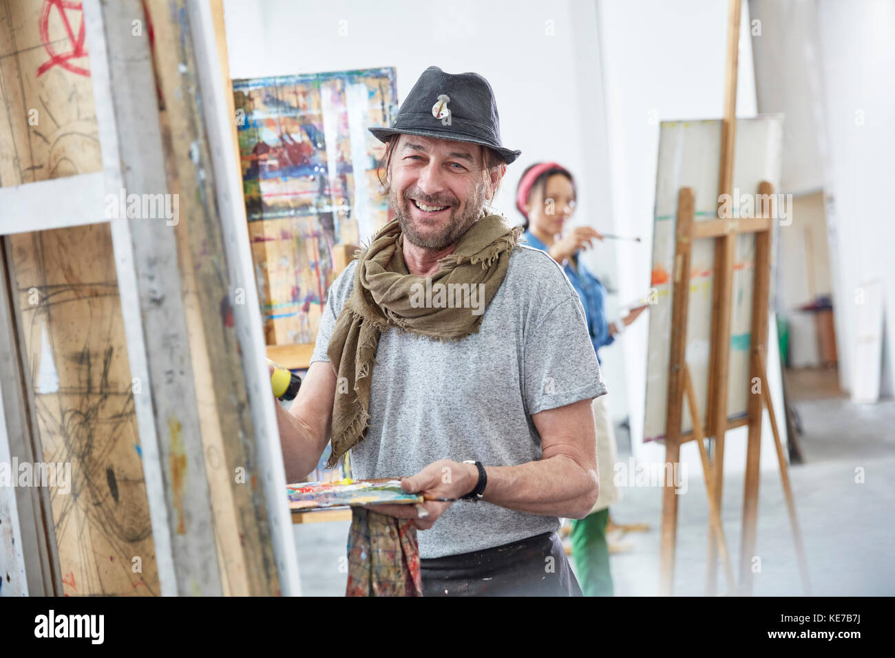 Portrait lächelnder männlicher Künstler Malerei an Staffelei in der Kunstklasse studio Stockfoto