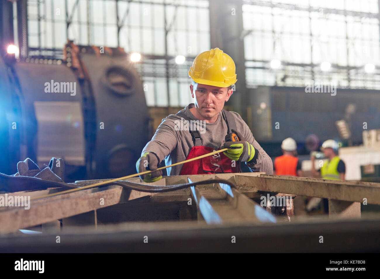 Männlicher Arbeiter mit Band messen Stahl in der Fabrik Stockfoto