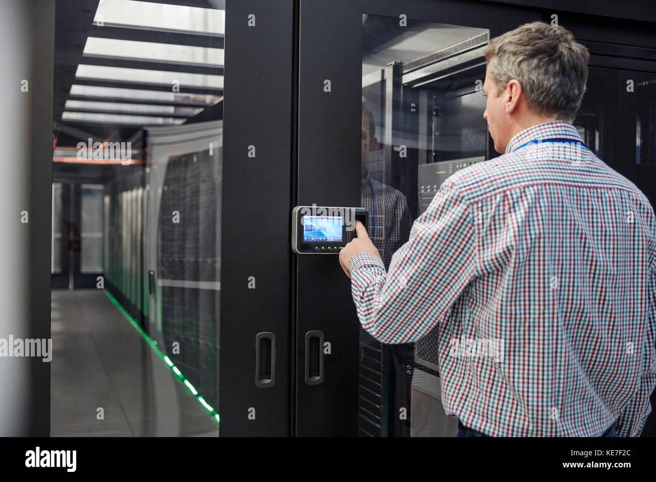 Männlicher IT-Techniker, der den Sicherheitscode beim Zugriff auf den Serverraum eingibt Tür Stockfoto