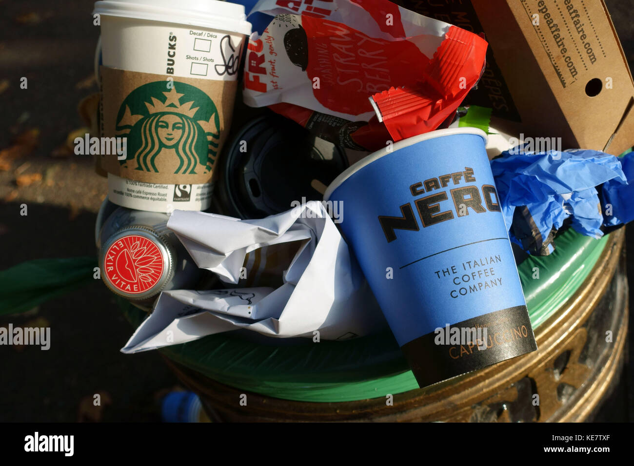 Nicht recycelbare Coffee Shop Tassen zum Mitnehmen in der Mülltonne auf der Straße, London Stockfoto