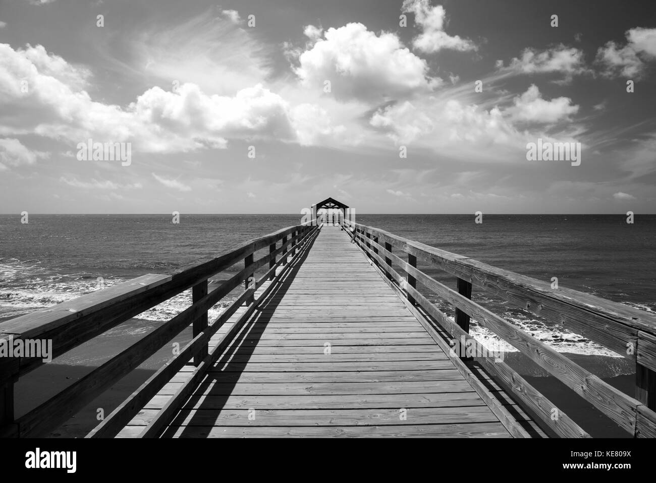 Schwarz-weiß-Bild von einem Pier, die auf das Meer mit einem überdachten Bereich am Ende; Hanalei, Kauai, Hawaii, Vereinigte Staaten von Amerika Stockfoto