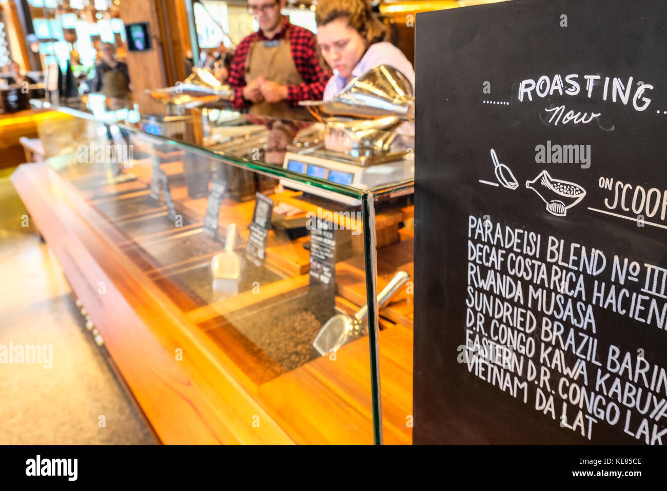 Zwei baristas Anordnen von Gebäck neben einem Braten Menü Stockfoto