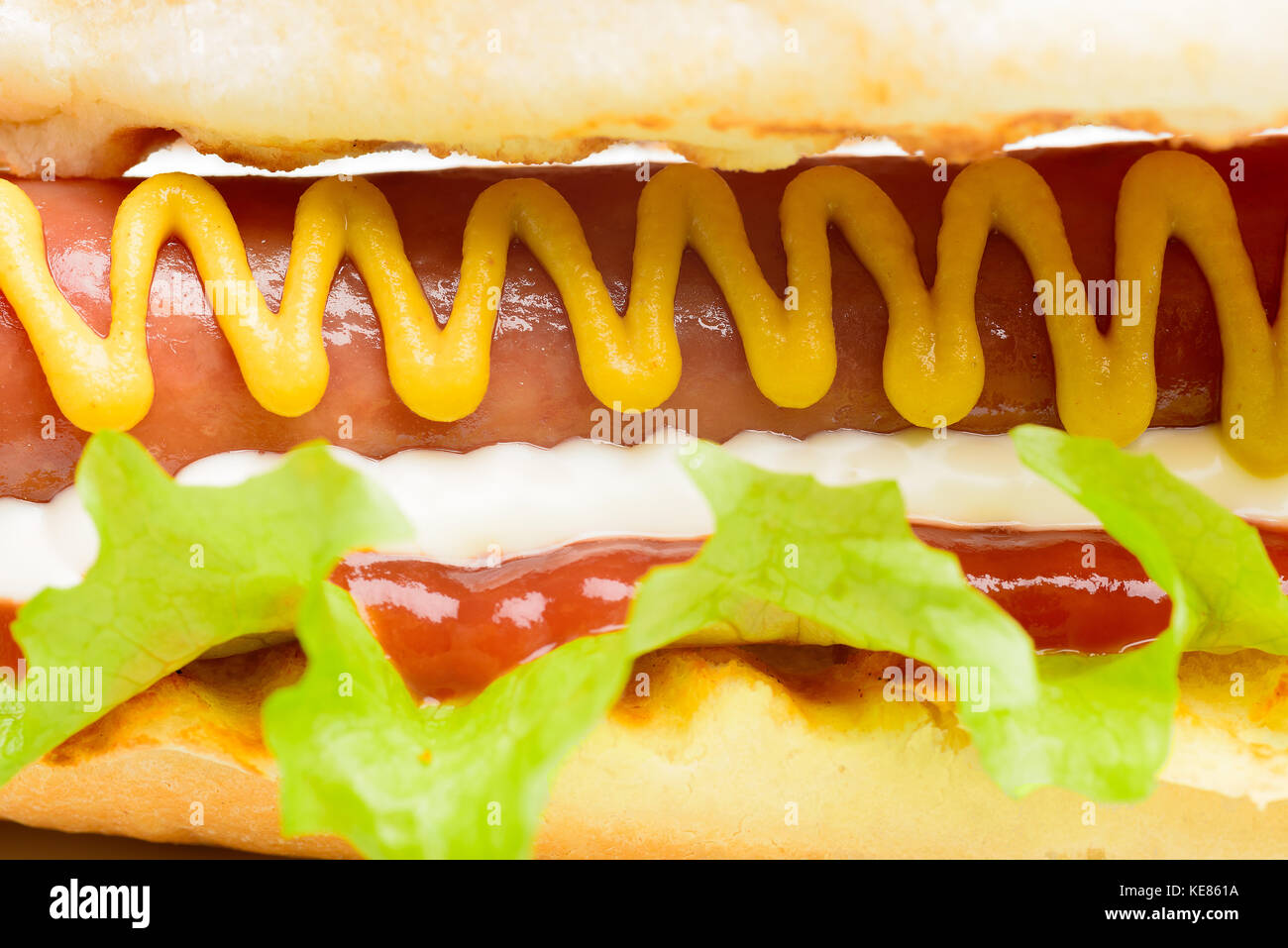 Appetitlich Hot Dog mit Senf isoliert auf weißem Stockfoto