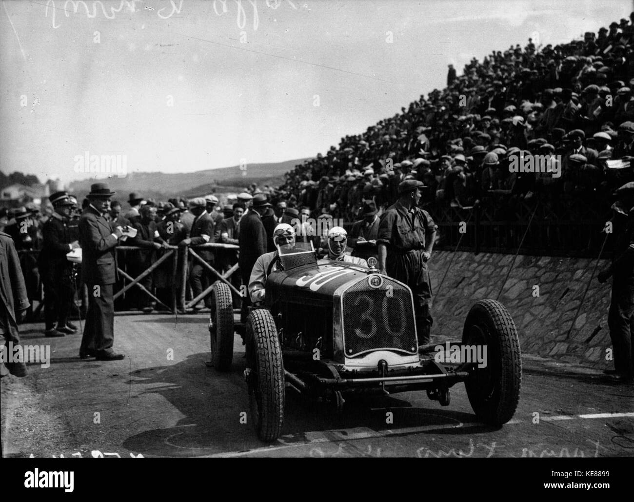 Dieses Bild zeigt Achille Varzi in seinem Alfa Romeo bei der Targa Florio 1930, einem der prestigeträchtigsten Straßenrennen Italiens, das die frühe Geschichte des Motorsports zeigt. Stockfoto