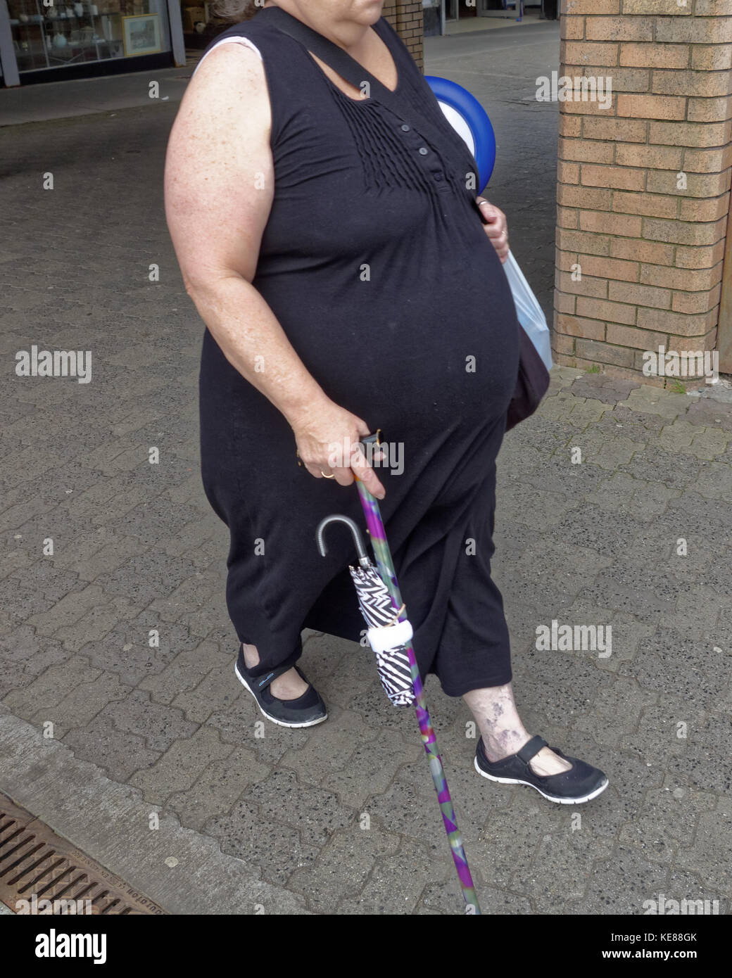 Große fat adipösen person Frau mit Stock abgeschnitten von vorne gesehen Stockfoto