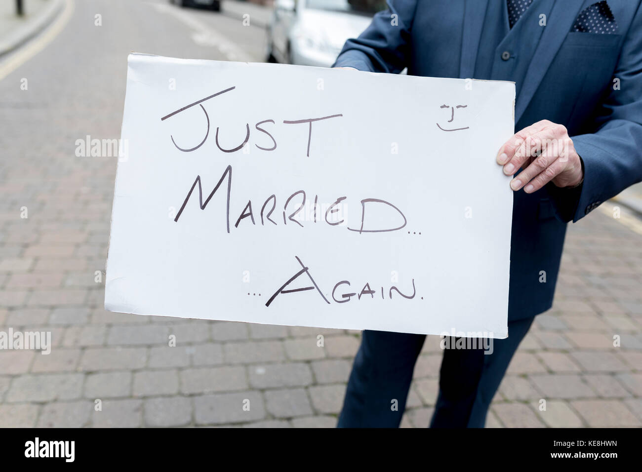 Bester Mann oder Bräutigam Holding eine humorvolle handgeschriebene Zeichen gerade geheiratet,... wieder auf einer zweiten Hochzeit oder die Erneuerung der Gelübde in Großbritannien Stockfoto