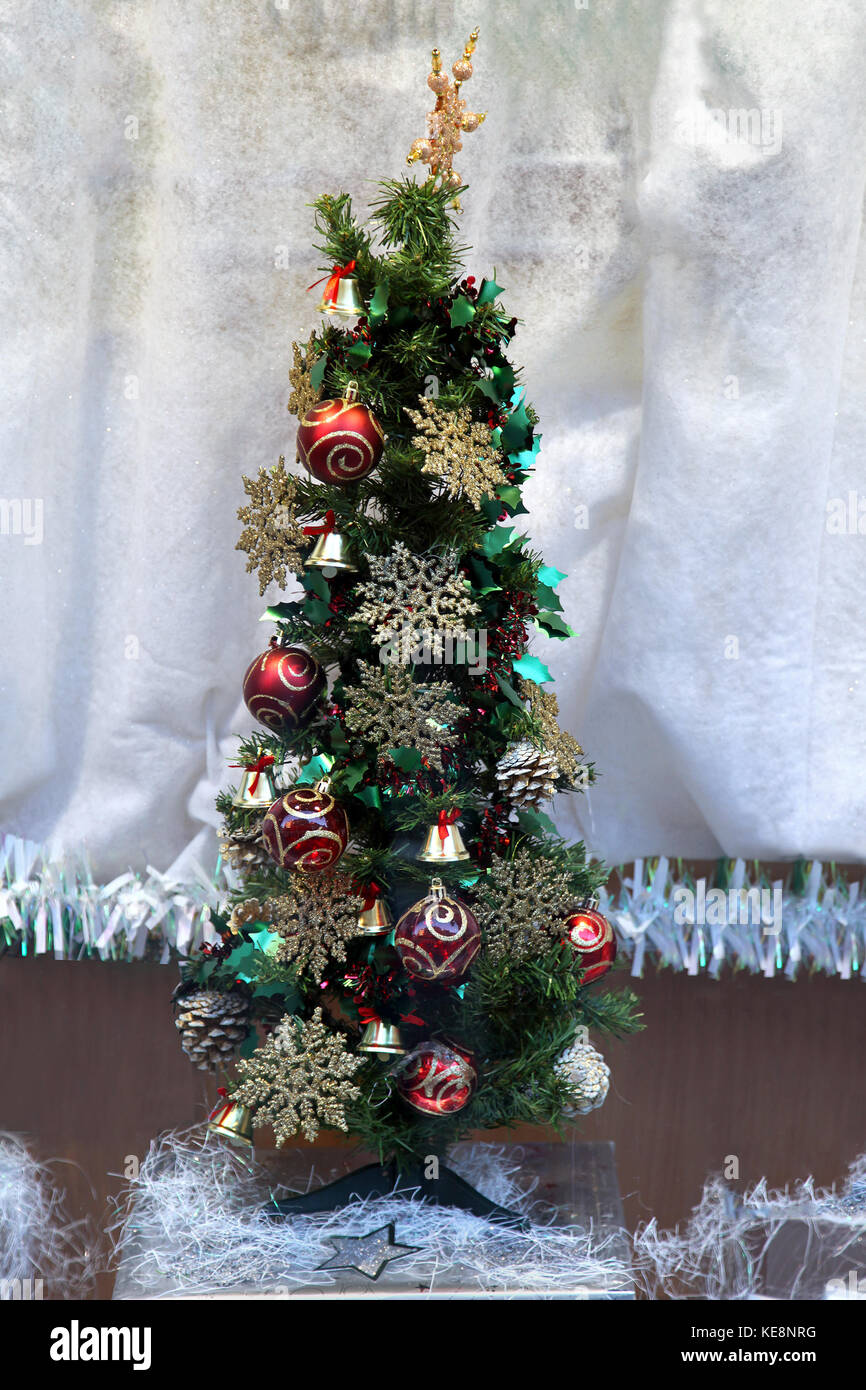 Kleine dekorative Weihnachtsbaum vor der weißen Tuch Stockfoto