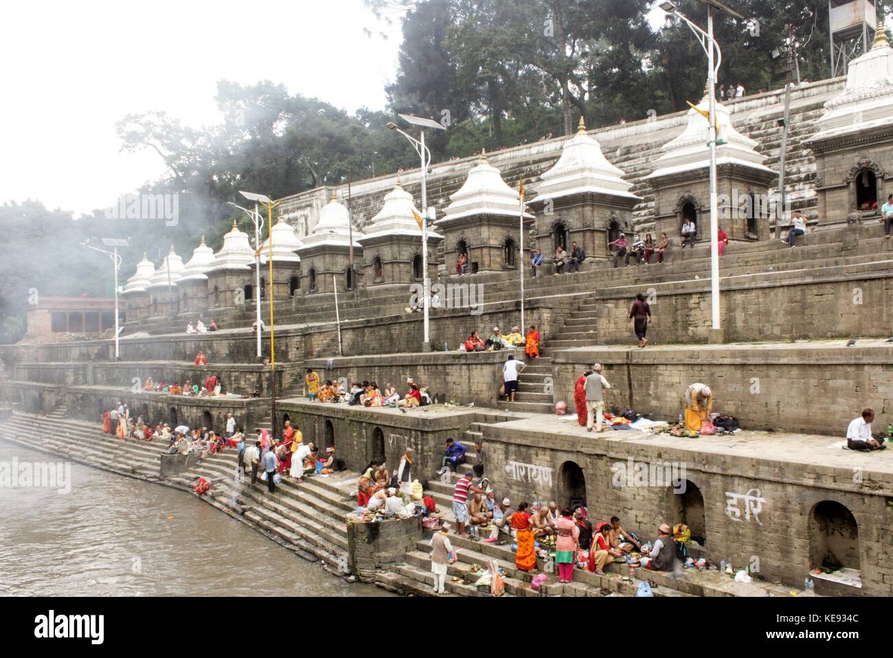 Noemie repetto/le pictorium - Nepal - kathmandu Pashupatinath Tempel. Welterbe seit 1979. - 20/09/2017 - Nepal/Kathmandu/Kathmandu - Nepal - Kathmandu. Der Tempel von Pashupatinath. Welterbe der Menschheit seit 1979. Die gegenüberliegende Bank zu, dass dort, wo die kremation durchgeführt werden. Familien dort niederlassen Essen und Angebote vorzubereiten, bevor sie in den Fluss schwimmen. Touristen mischen sich mit Familien, die die Zeremonie der seine Intimität beraubt. Diese Seite hat auch 11 weißen Tempeln. Stockfoto