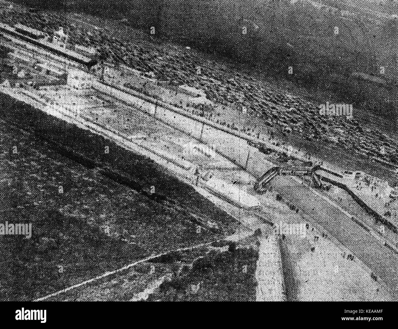 Eine Szene aus den 24 Stunden von Le Mans 1933, die die Tribünen (les tribunes), die Ecke (le virage) und die Fußgängerbrücke (la passerelle) zeigt. Diese Veranstaltung war ein wichtiger Moment in der Geschichte des Motorsports und zeigte die Intensität und Spannung des Rennens. Stockfoto