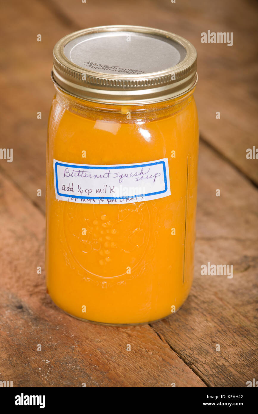 Glas homecanned butternut Kürbis Suppe, ruht auf einem rustikalen, mit Holz der Tischplatte Stockfoto