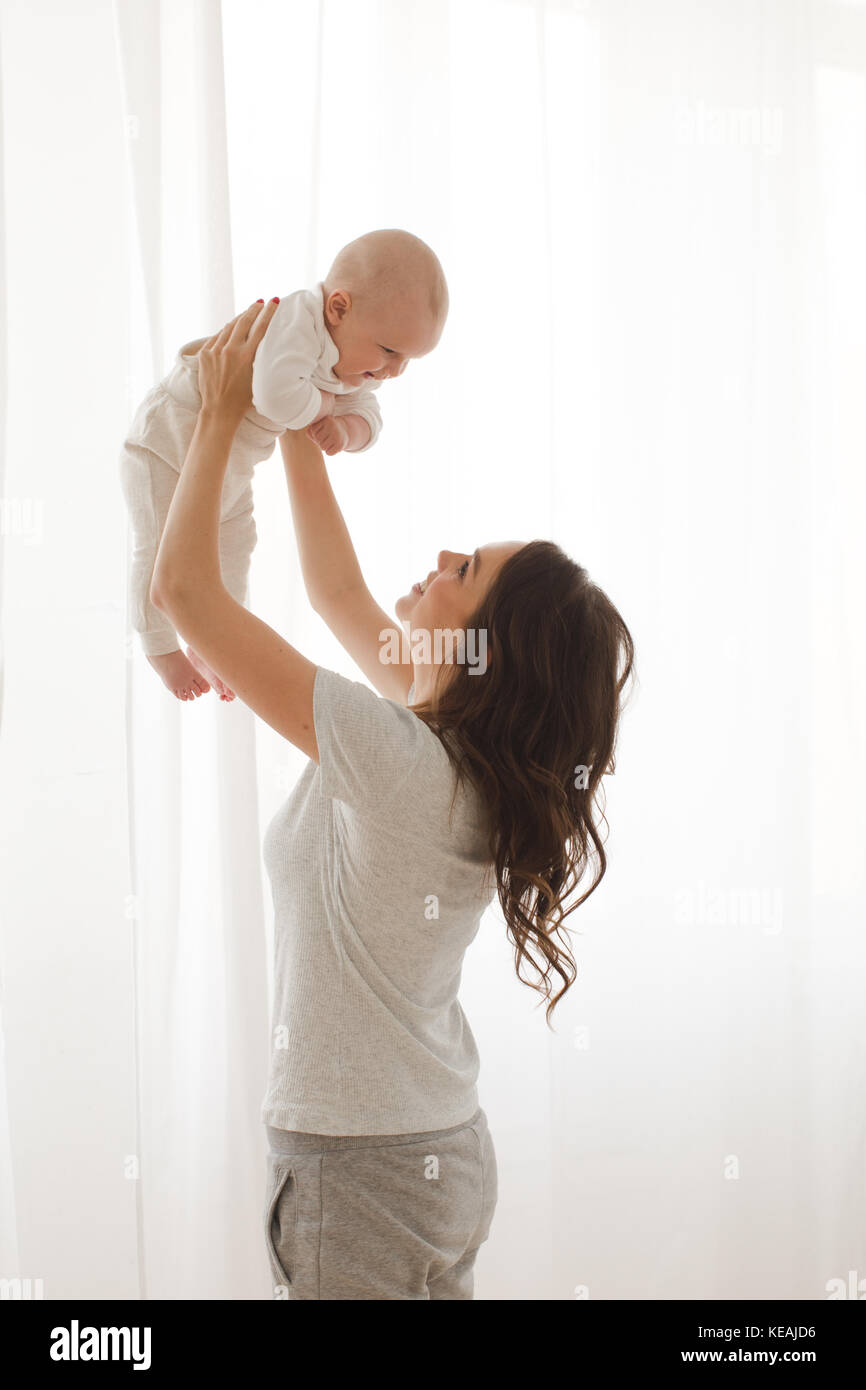 Mama hält ein Baby in den Armen Fenster mit weißem Hintergrund Stockfoto