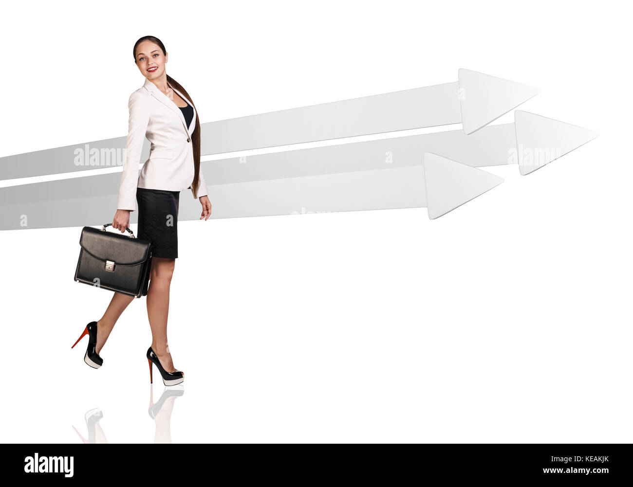 Geschäftsfrau zu Fuß in der Nähe der großen grauen Pfeile. Stockfoto